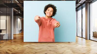 African american little boy isolated cheerful smiles pointing to front. Wall mural