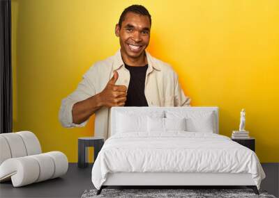 African American man with shirt, yellow studio, raising both thumbs up, smiling and confident. Wall mural