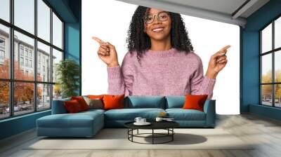 African American woman in studio setting pointing to different copy spaces, choosing one of them, showing with finger. Wall mural