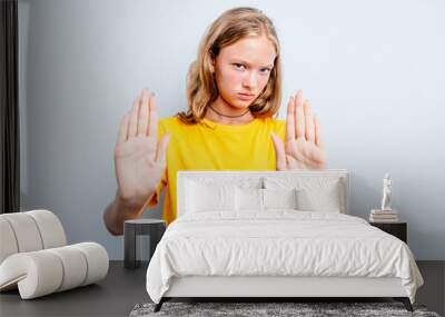 Caucasian teen girl isolated on blue background standing with outstretched hand showing stop sign, preventing you. Wall mural