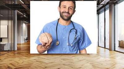 Hispanic male nurse holding brain happy, smiling and cheerful. Wall mural