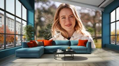 Joyful close-up of young caucasian woman in a park. Wall mural