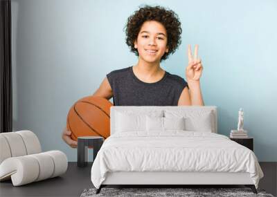 Kid boy playing basketball isolated on blue background showing number two with fingers. Wall mural