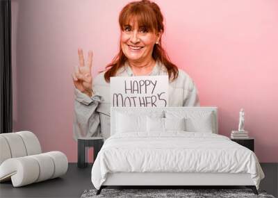 Middle age caucasian woman holding Happy mother’s day placard isolated on pink background showing number two with fingers. Wall mural