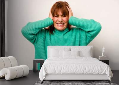 Middle age caucasian woman isolated on white background covering ears with hands trying not to hear too loud sound. Wall mural