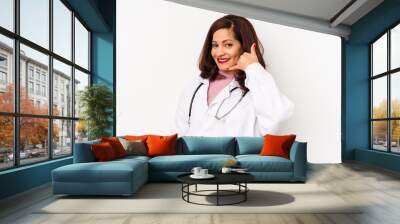 Middle age latin doctor woman isolated showing a mobile phone call gesture with fingers. Wall mural