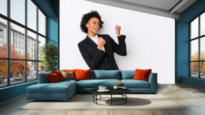 Middle aged african american business  woman against a white background isolated raising fist after a victory, winner concept. Wall mural