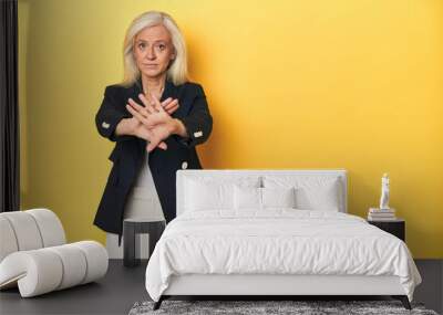 Middle-aged Caucasian woman in business jacket, yellow studio doing a denial gesture Wall mural