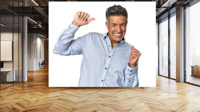 Middle-aged Latino man celebrating a special day, jumps and raise arms with energy. Wall mural