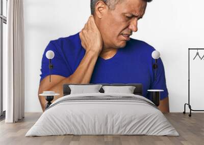 middle-aged latino man having a neck pain due to stress, massaging and touching it with hand. Wall mural