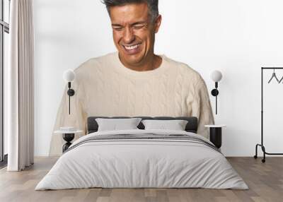 Middle-aged Latino man laughs and closes eyes, feels relaxed and happy. Wall mural