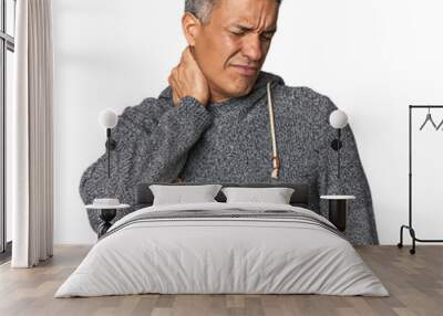 Middle-aged Latino man suffering neck pain due to sedentary lifestyle. Wall mural