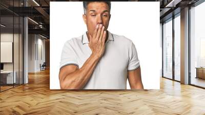 Middle-aged Latino man yawning showing a tired gesture covering mouth with hand. Wall mural