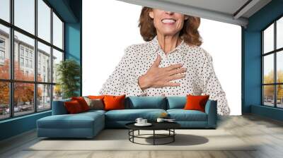 Redhead mid-aged Caucasian woman in studio laughs happily and has fun keeping hands on stomach. Wall mural