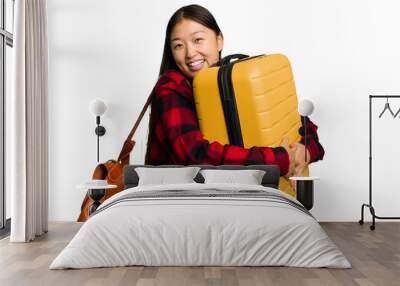 Traveler asian woman holding a suitcase isolated Wall mural