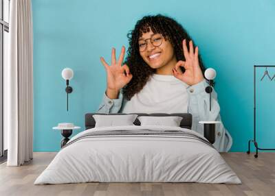 Young african american afro woman isolated cheerful and confident showing ok gesture. Wall mural