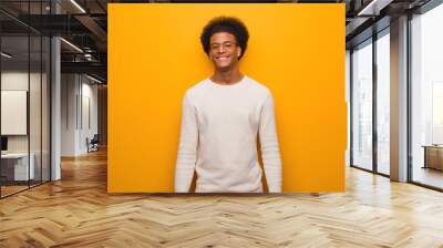 Young african american man over an orange wall cheerful with a big smile Wall mural