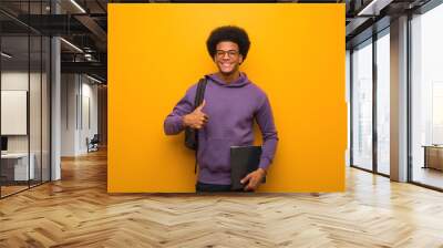 Young african american student man smiling and raising thumb up Wall mural