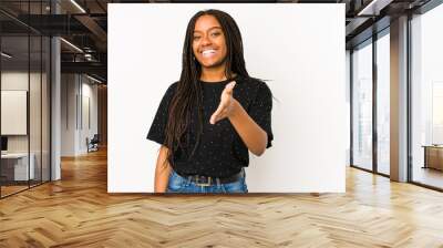 Young african american woman isolated on white background stretching hand at camera in greeting gesture. Wall mural