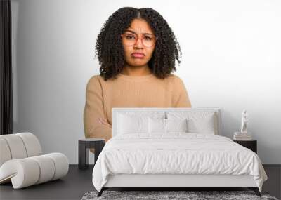 Young african american woman isolated suspicious, uncertain, examining you. Wall mural