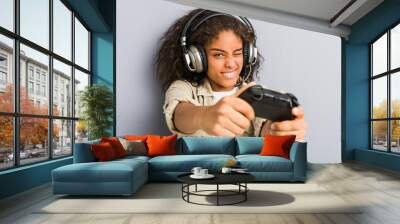 Young african american woman using headphones and game controller Wall mural