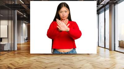 Young Asian woman isolated on green chroma background standing with outstretched hand showing stop sign, preventing you. Wall mural