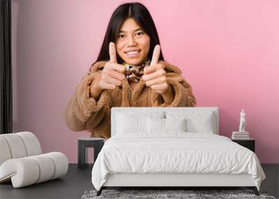 Young asian woman with thumbs ups, cheers about something, support and respect concept. Wall mural