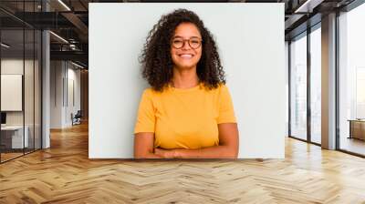 Young Brazilian woman isolated on blue background who feels confident, crossing arms with determination. Wall mural