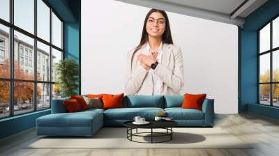 Young business arab woman isolated against a white background has friendly expression, pressing palm to chest. Love concept. Wall mural