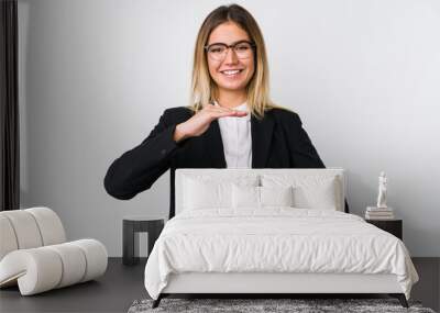 Young business caucasian woman holding something with both hands, product presentation. Wall mural