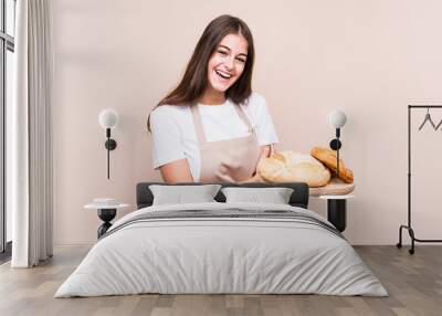 Young caucasian baker woman isolated laughing and having fun. Wall mural