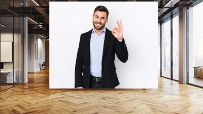 Young caucasian business man against a white background isolated cheerful and confident showing ok gesture. Wall mural