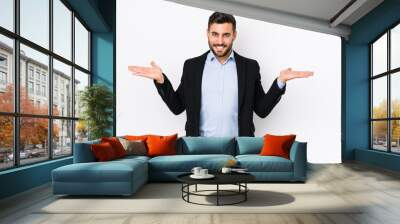 Young caucasian business man against a white background isolated makes scale with arms, feels happy and confident. Wall mural