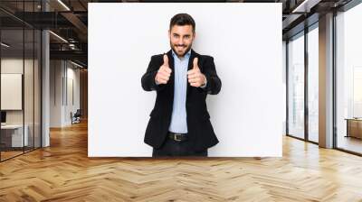 Young caucasian business man against a white background isolated with thumbs ups, cheers about something, support and respect concept. Wall mural