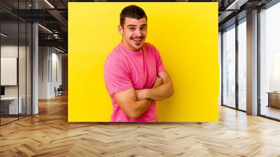 Young caucasian cool man isolated on yellow background laughing and having fun. Wall mural