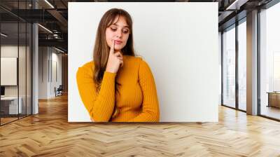 Young caucasian cute woman isolated on white background looking sideways with doubtful and skeptical expression. Wall mural