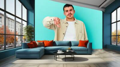 Young caucasian man isolated on blue background showing thumb down, disappointment concept. Wall mural