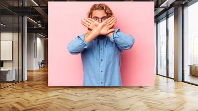 Young caucasian man isolated on pink background doing a denial gesture Wall mural