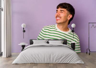 Young caucasian man isolated on purple background relaxed and happy laughing, neck stretched showing teeth. Wall mural