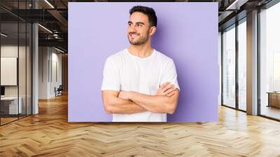 Young caucasian man isolated on purple background smiling confident with crossed arms. Wall mural