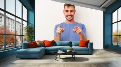 Young caucasian man isolated on white background excited pointing with forefingers away. Wall mural