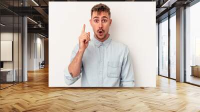 Young caucasian man isolated on white background person pointing by hand to a shirt copy space, proud and confident Wall mural