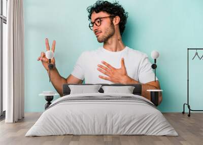 Young caucasian man isolated on white background taking an oath, putting hand on chest. Wall mural