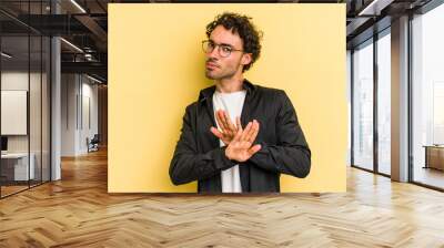 Young caucasian man isolated on yellow background doing a denial gesture Wall mural