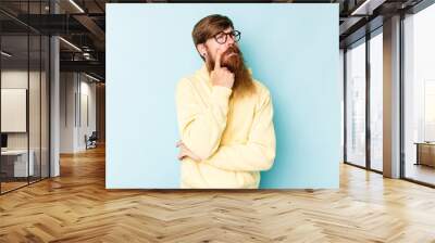 Young caucasian red-haired man isolated on blue background crying, unhappy with something, agony and confusion concept. Wall mural