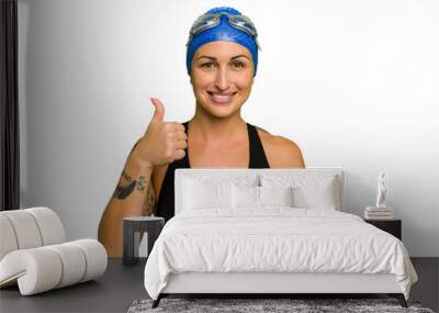 Young caucasian swimmer woman isolated on green chroma background smiling and raising thumb up Wall mural