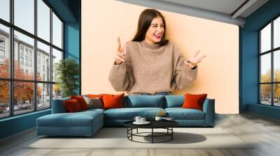 Young caucasian woman isolated en beige background joyful laughing a lot. Happiness concept. Wall mural