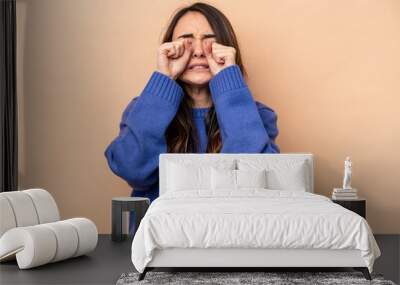 Young caucasian woman isolated on beige background whining and crying disconsolately. Wall mural