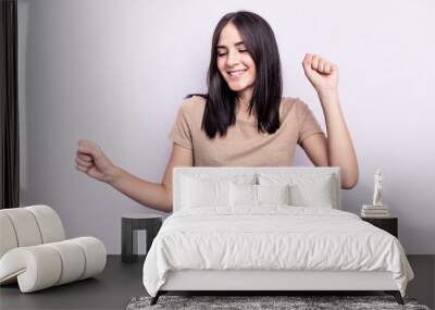 Young caucasian woman isolated on pink background dancing and having fun. Wall mural