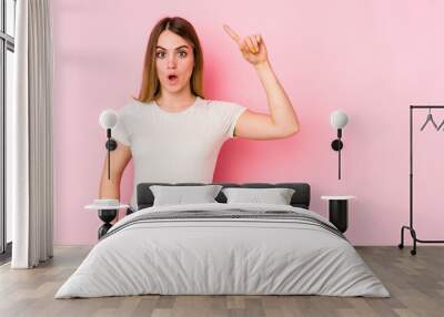 Young caucasian woman isolated on pink background having some great idea, concept of creativity. Wall mural